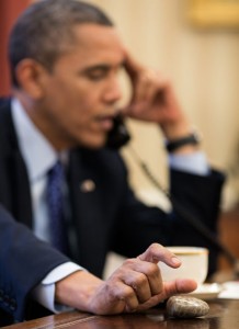 President Barack Obama plays with a Petoskey stone as he talks on the phone in the Oval Office, Dec. 6, 2012. Official White House Photo by Pete Souza, via The White House.